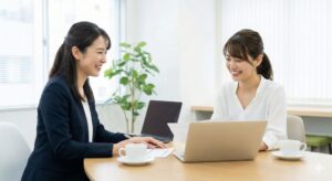 女性税理士とマンツーマンで笑顔で税金相談をするサロンオーナー